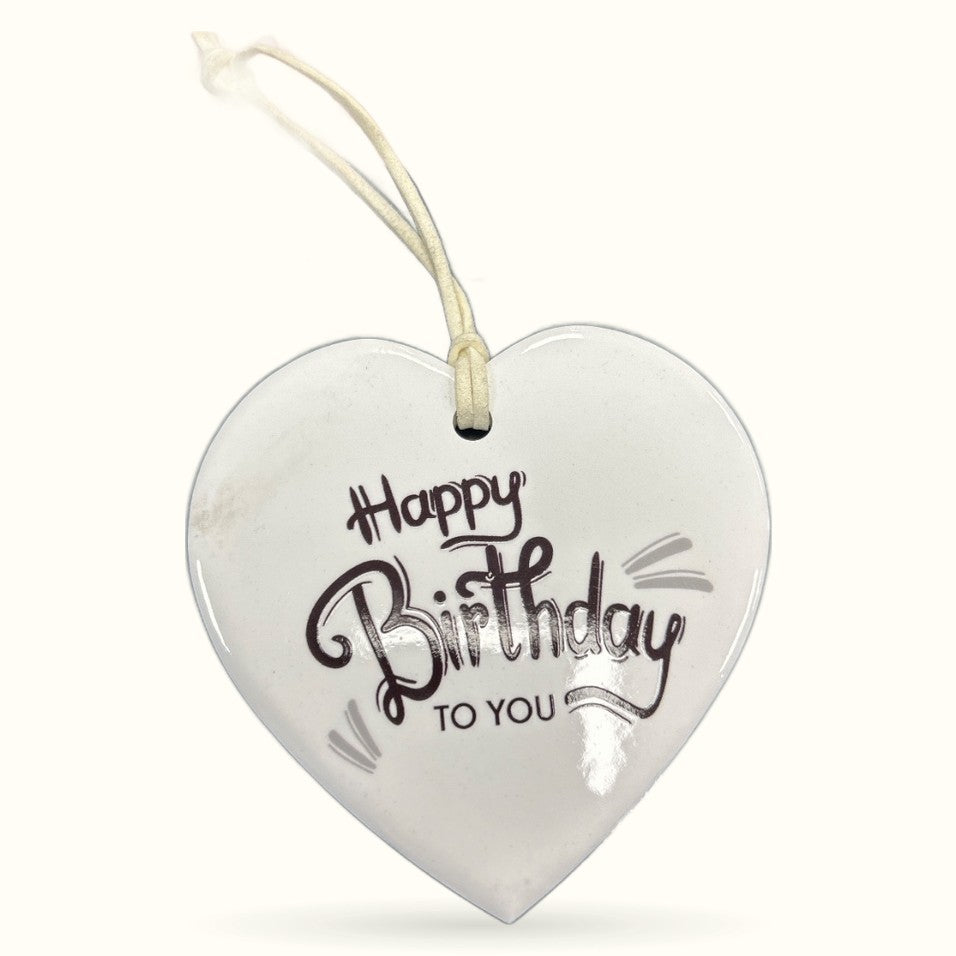 White ceramic heart plaque with 'Happy Birthday To You' text and cream ribbon hanging loop