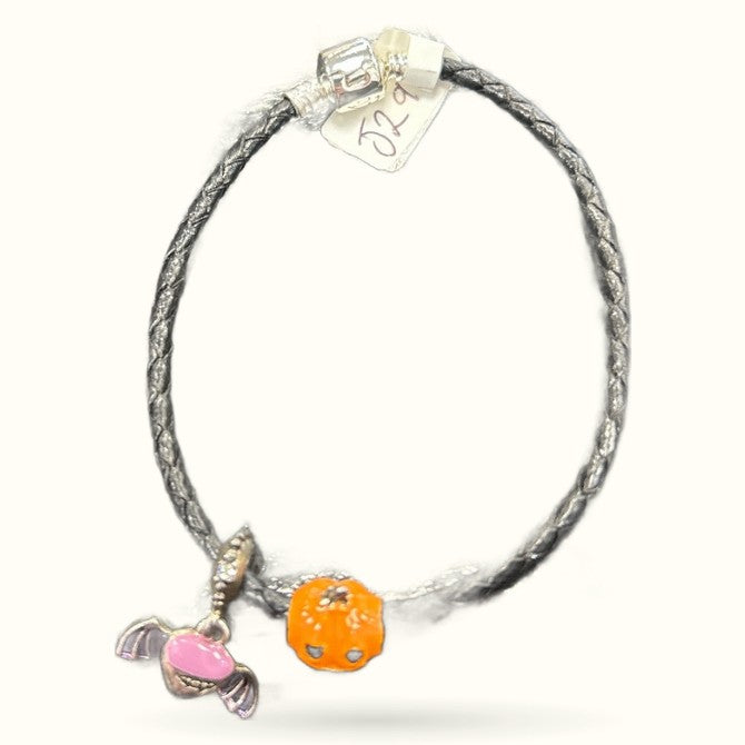 Grey braided leather cord bracelet with orange pumpkin charm and pink candy charm
