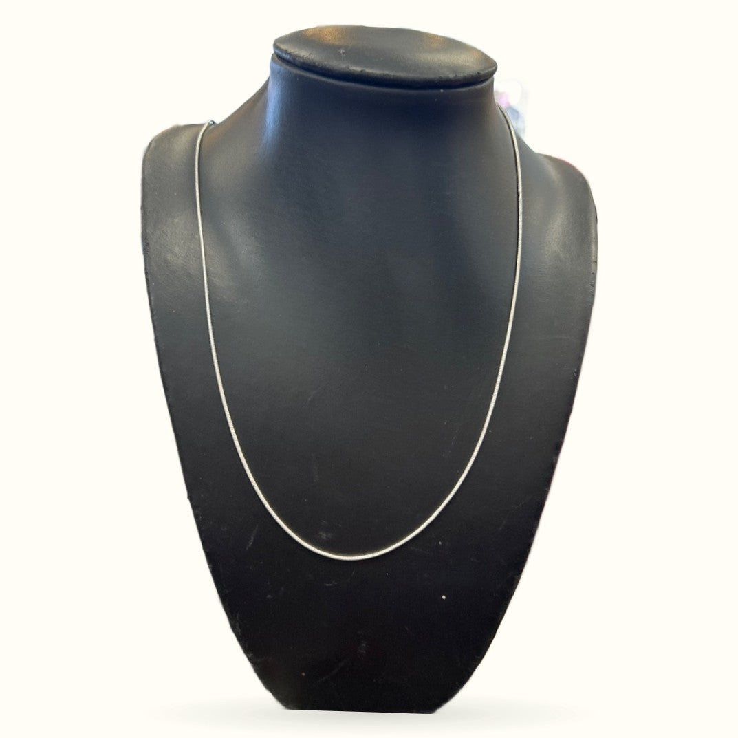 Silver chain necklace displayed on black mannequin bust, showing sleek snake chain design