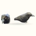 Two carved wooden black bird figures shown from different angles - head detail and full body profile view
