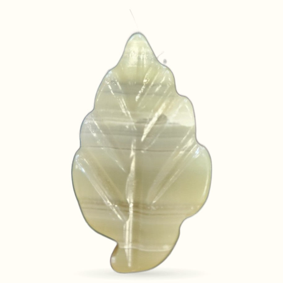 Pale yellow-green calcite crystal carved into a leaf shape with visible natural striations
