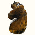 Polished tiger's eye stone unicorn head pendant with loop attachment, warm golden-brown tones