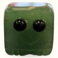 Green aventurine block buddy with two black tourmaline eyes and a smiling mouth