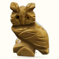 Golden-brown soapstone owl carving with detailed feather etching and dark stone eyes