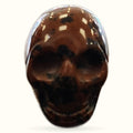 Polished rhodonite skull with deep brown and cream coloring, glossy finish