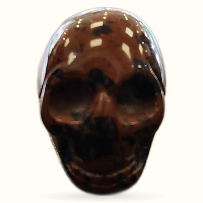 Polished rhodonite skull with deep brown and cream coloring, glossy finish