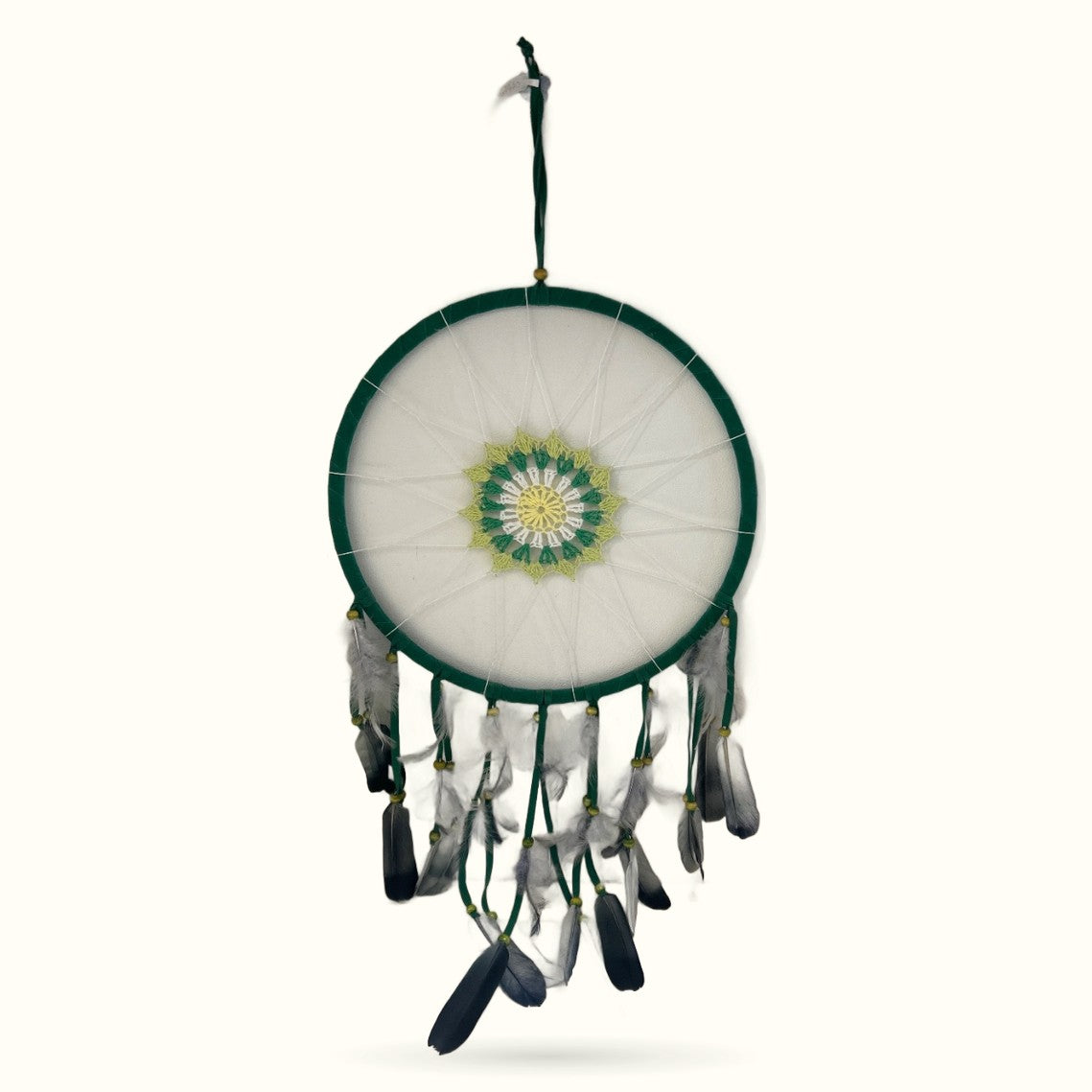 Large green woven dream catcher with white mesh center, green and yellow mandala design, and hanging feathers