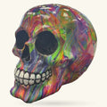 Colorful rainbow swirl skull ornament with white teeth, displayed against neutral background
