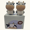 Two ceramic cow salt and pepper shakers with black and white coloring, smiling faces, displayed with product box