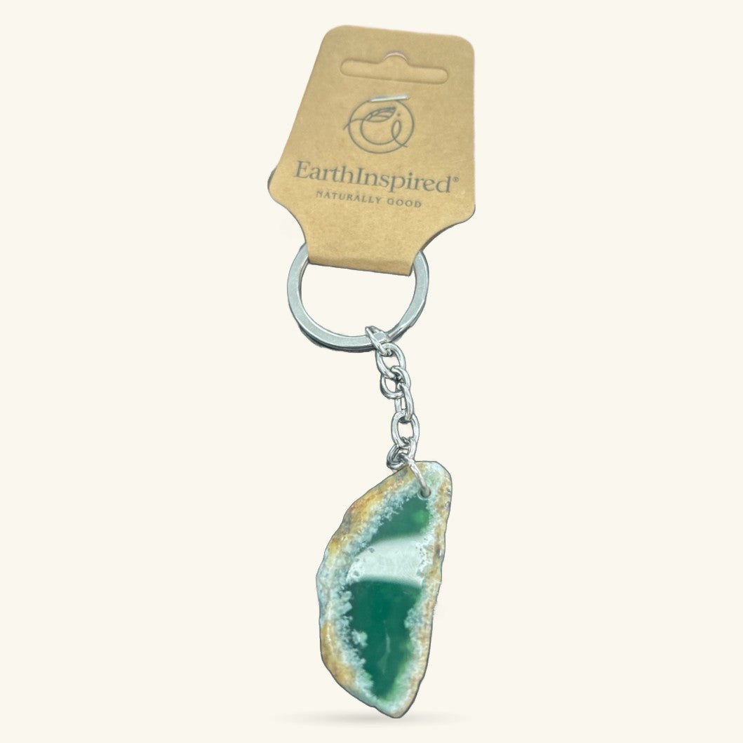 Green agate slice keychain with silver chain and ring, attached to EarthInspired packaging tag