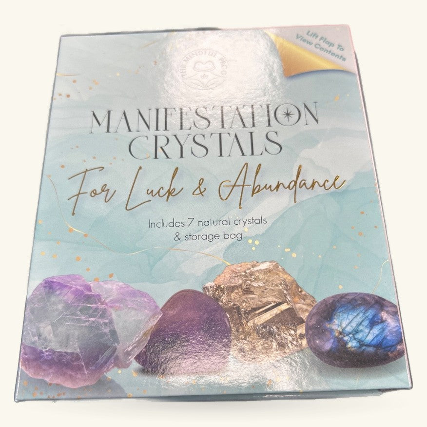 Manifestation Crystals For Luck & Abundance kit box displaying 7 natural crystals including amethyst, labradorite, and gold-leafed specimens with storage bag
