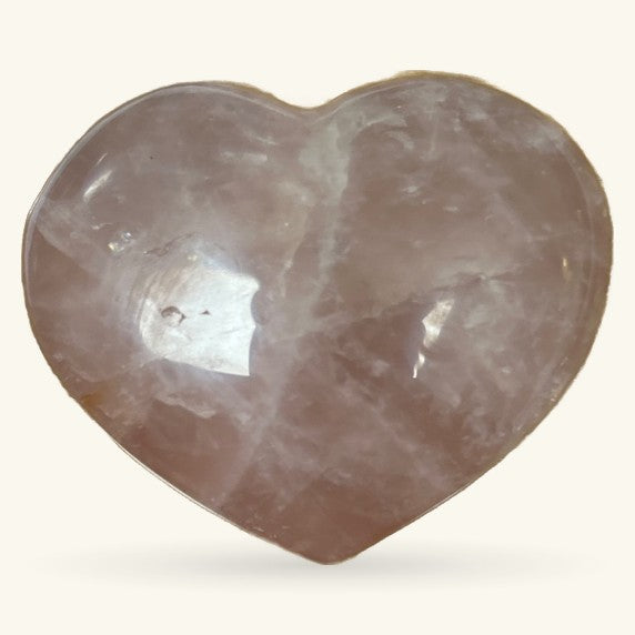 Polished rose quartz heart-shaped stone, pale pink with natural inclusions and a glossy finish