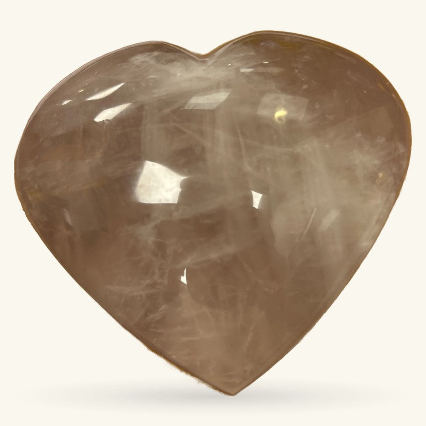 Polished rose quartz heart crystal, pale pink-beige tone, smooth glossy finish