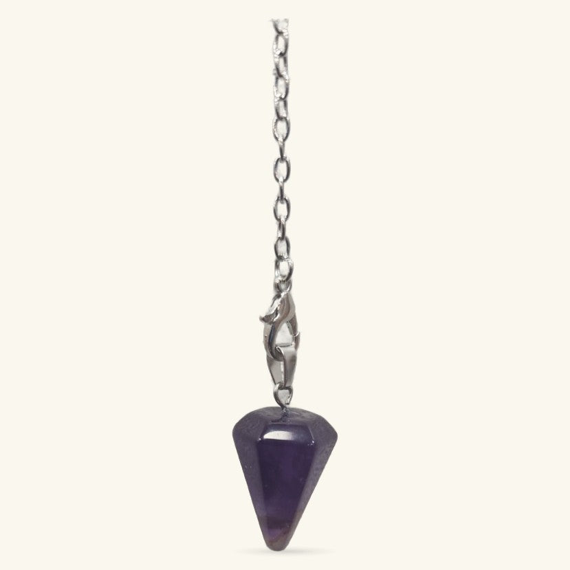 Mini amethyst point pendulum with silver chain and clasp on cream background