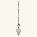 Rose quartz point pendulum with metal clasp hanging from silver chain on cream background