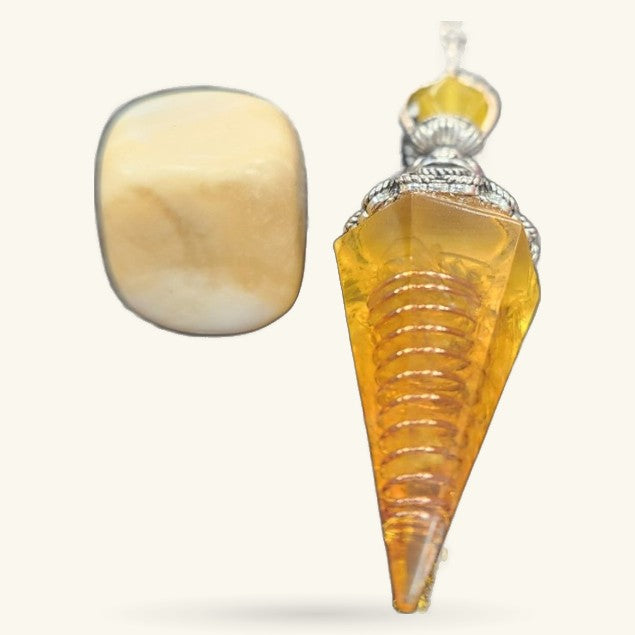Citrine tumble stone and ornate golden citrine pendulum displayed side by side on white background