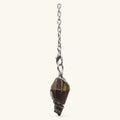 Tiger's Eye dowsing pendulum with brown banded stone in silver wire wrap, hanging from chain