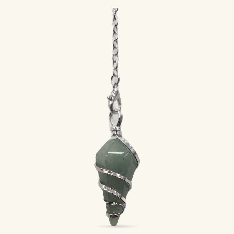 Green aventurine dowsing pendulum with silver wire wrapping on chain against cream background