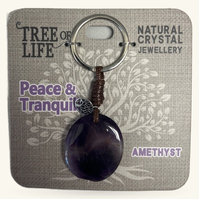 Purple amethyst sphere keychain with tree of life charm on beaded cord, displayed on branded packaging
