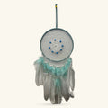 Teal fabric dreamcatcher with white lace center, blue beads, teal and white feathers, hanging cord