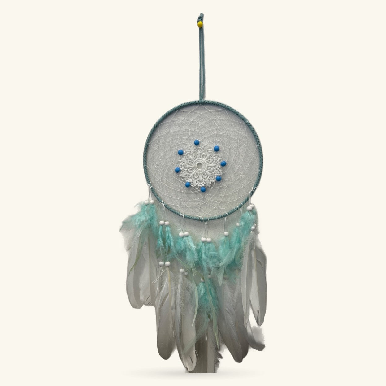 Teal fabric dreamcatcher with white lace center, blue beads, teal and white feathers, hanging cord