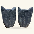 Pair of dark stone owl bookends with spiral eye details and embossed flower patterns on body