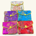 Six colorful embroidered small purses arranged in rows, featuring floral designs with yellow button closures