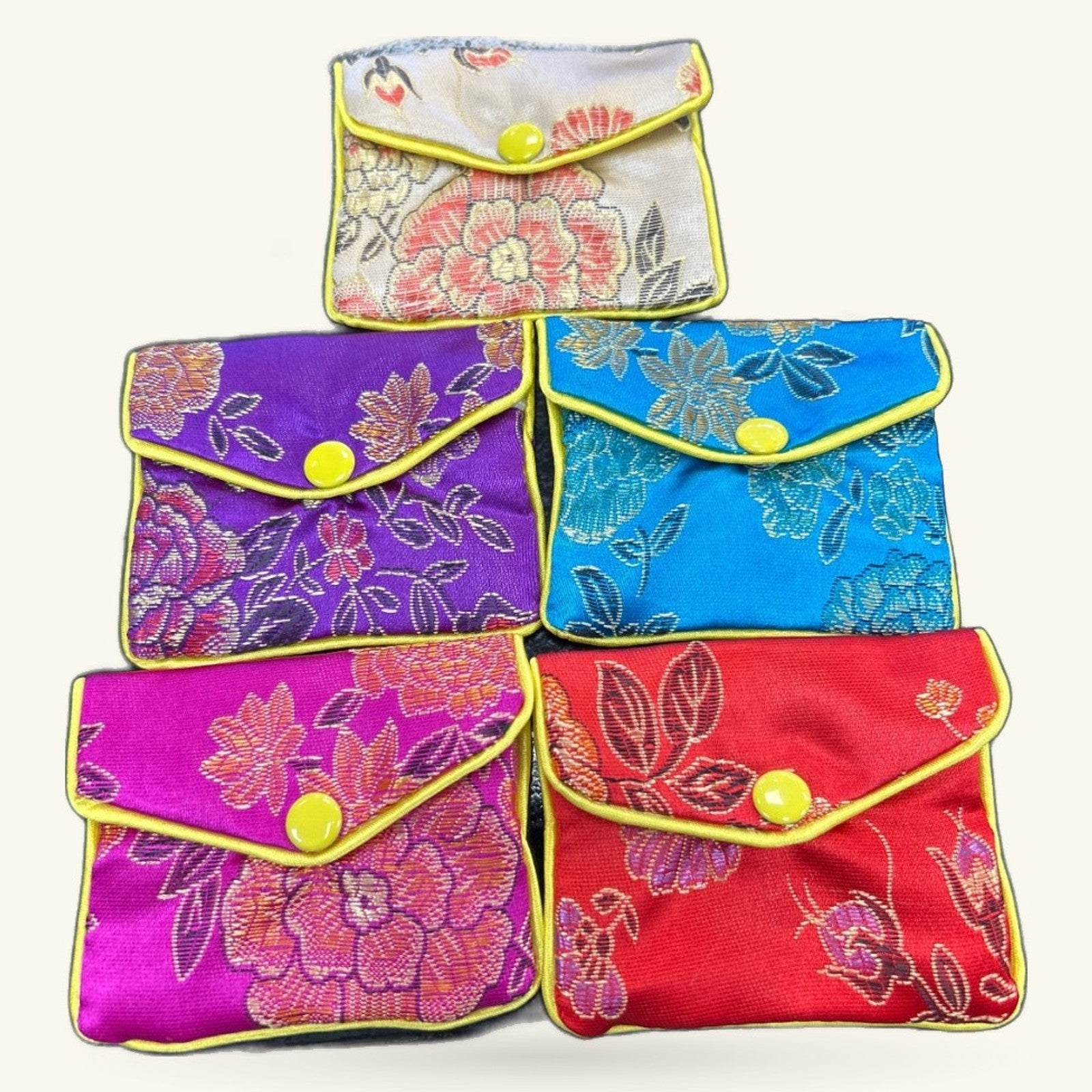 Six colorful embroidered small purses arranged in rows, featuring floral designs with yellow button closures