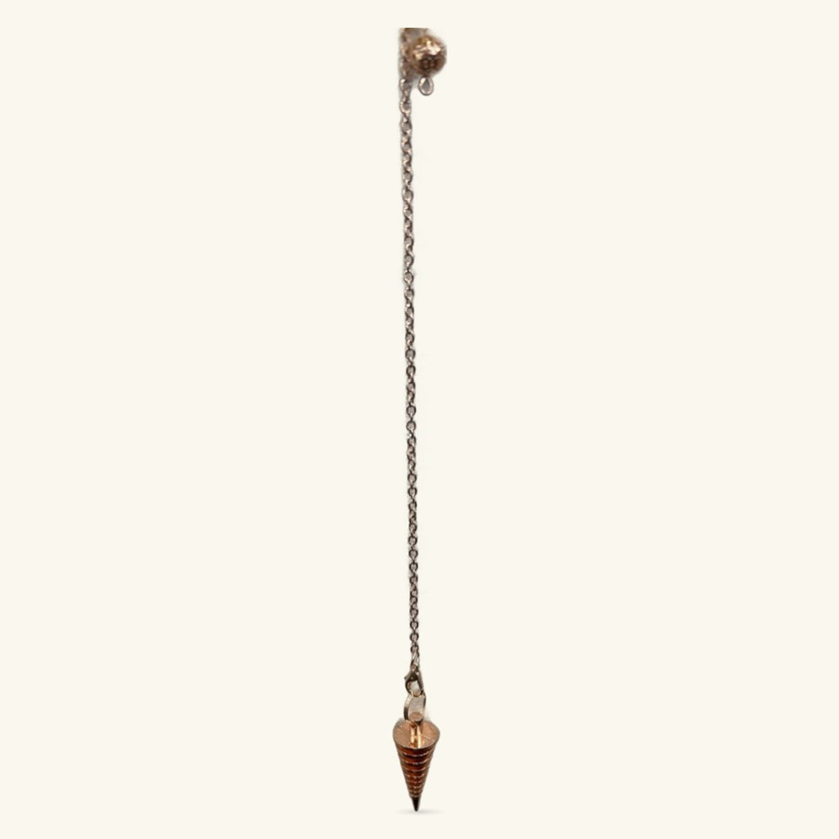 Rose gold metal dowsing pendulum with chain and pointed cone weight on white background