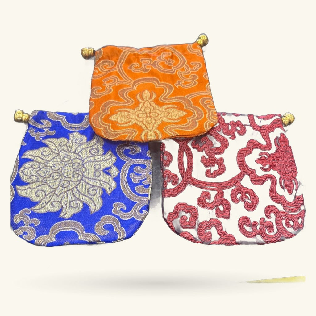 Three decorative Chinese embroidery fabric purses in orange, blue, and red with gold ornamental patterns and brass bead closures