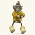 Ceramic Highland cow figurine wearing yellow sweater and festive hat with dangly rope legs