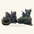 Two black dragon figurines holding colorful crystal orbs – amber and green stones