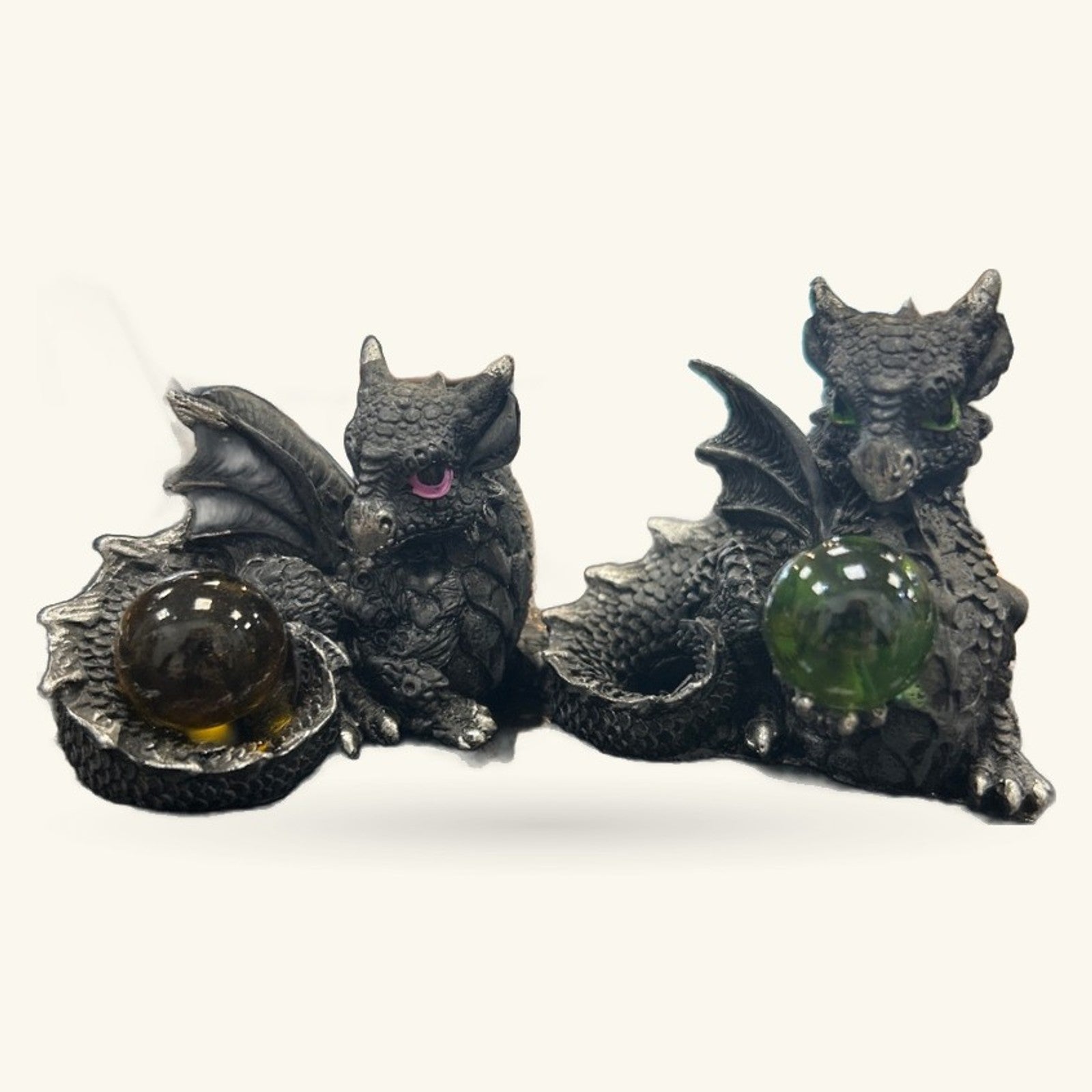 Two black dragon figurines holding colorful crystal orbs – amber and green stones