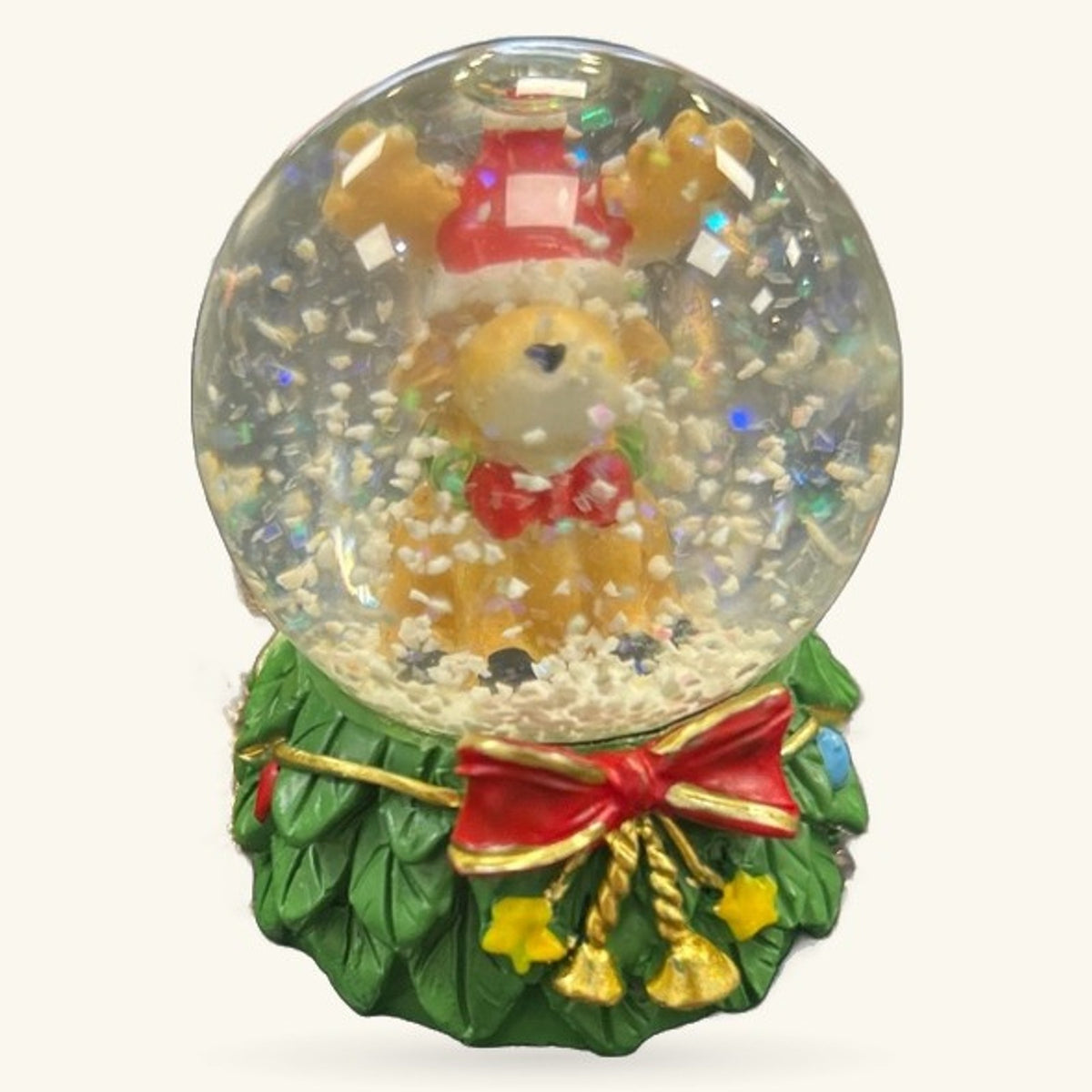Reindeer snow globe with green wreath base, red bow, and gold bells