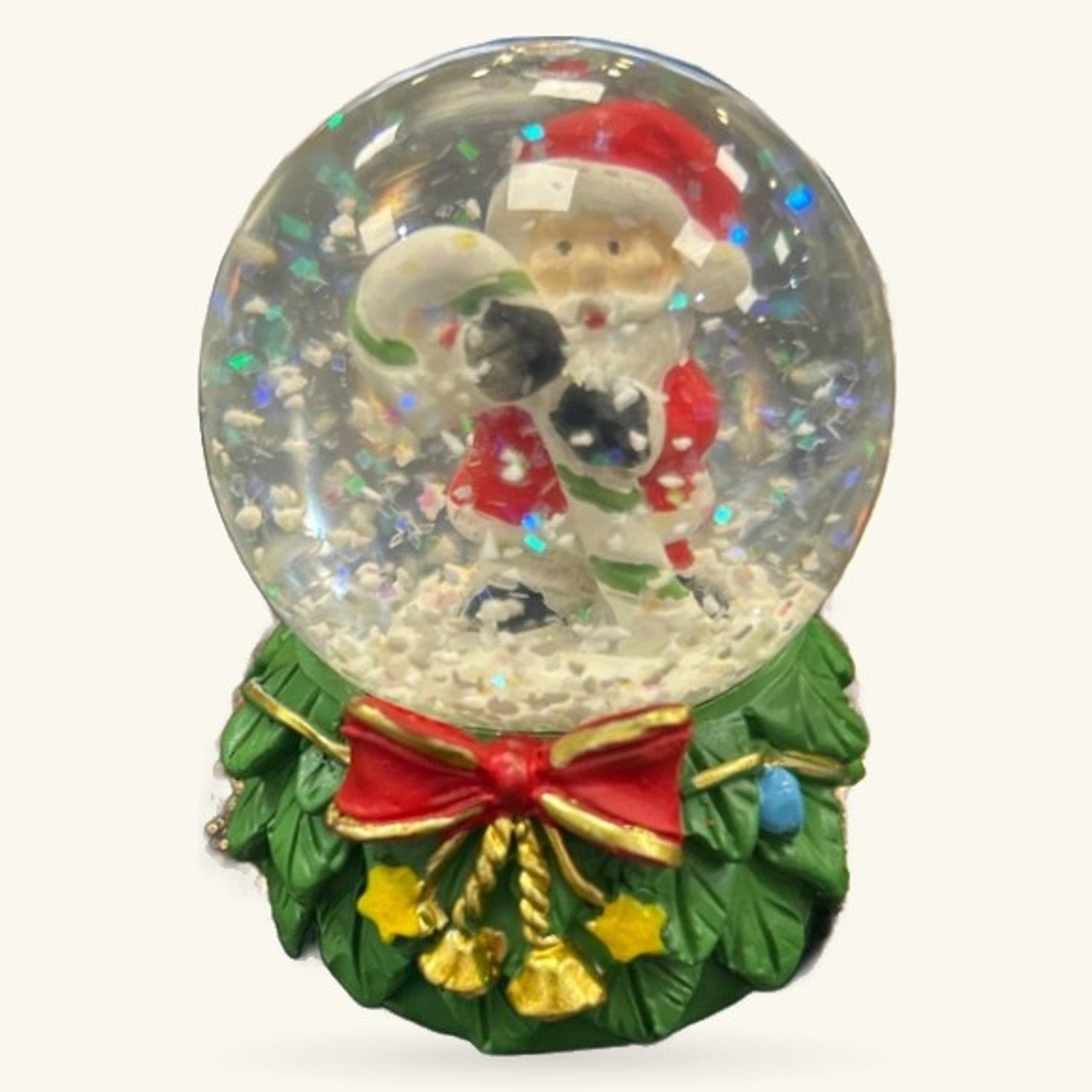 Santa snow globe with green wreath base, red bow, gold bells, and colorful glitter inside clear dome