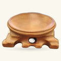 Wooden crystal stand with curved elephant-shaped base, natural honey-brown finish, small white stone accent