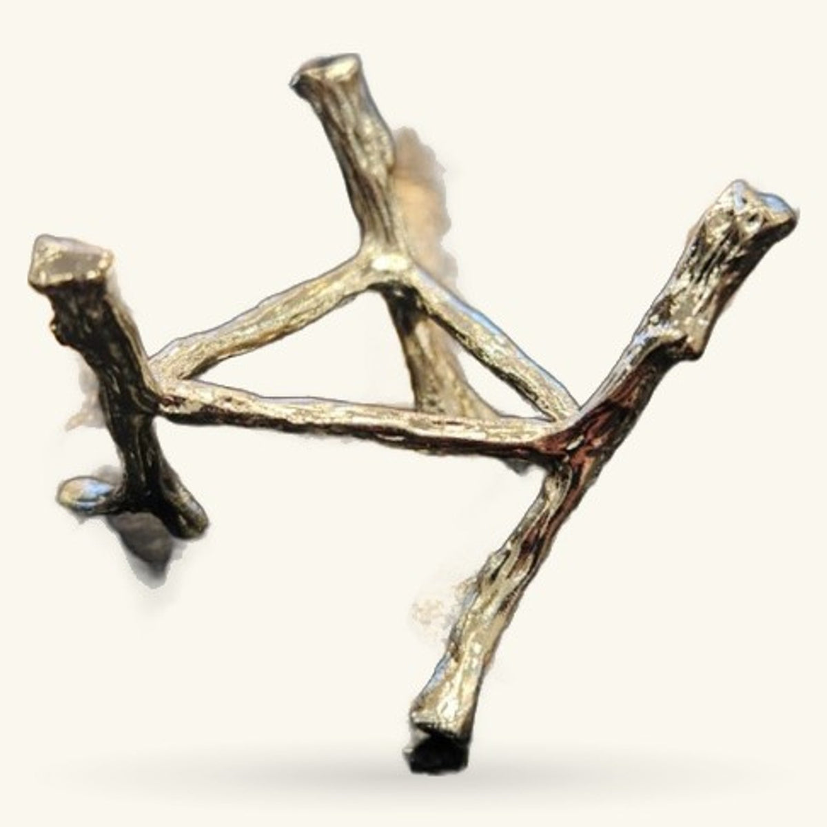 Brass-toned metal tree crystal stand with three branch-like arms holding polished stones