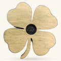 Wooden four-leaf clover charm with natural wood finish and black circular center, on white background