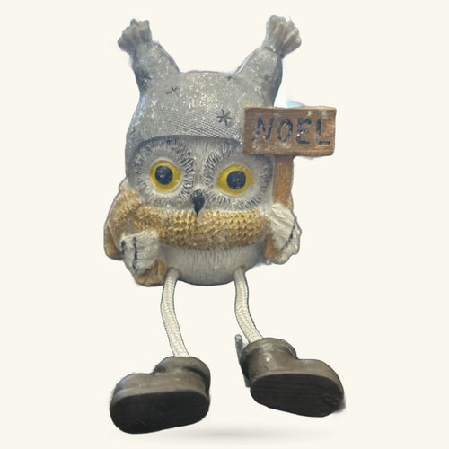 Grey and white Christmas owl decoration with golden chest, dangly black legs, and wooden Noel sign