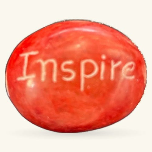 Red polished stone with 'Inspire' engraved on surface, oval shape, 3cm size