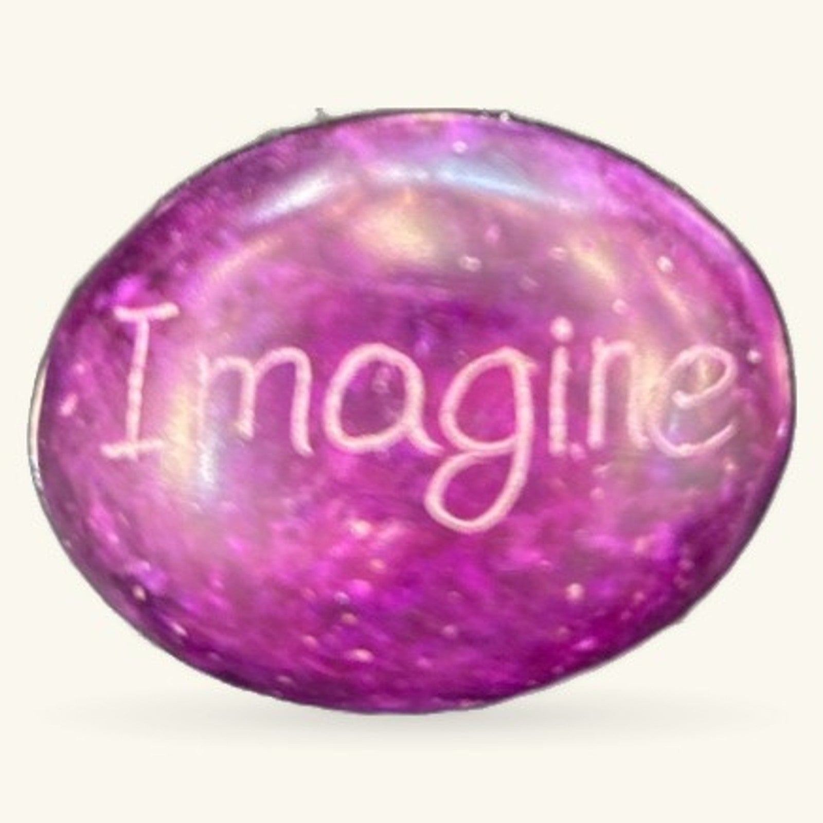 Purple polished stone with 'Imagine' engraved in white text, smooth oval shape with iridescent finish
