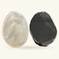 Two polished agate slice pendants shown front and back - one milky translucent, one dark charcoal with drilling hole