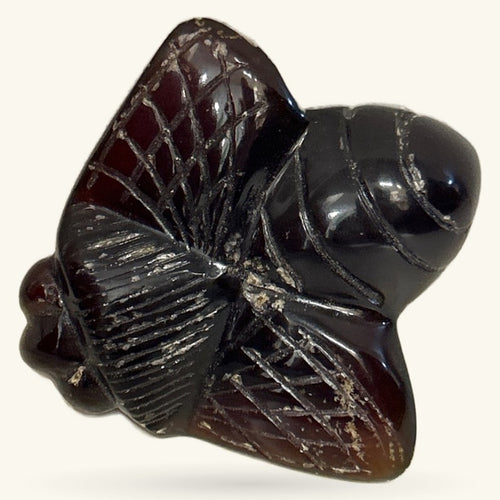 Dark polished amber bee carving with intricate wing details and glossy finish
