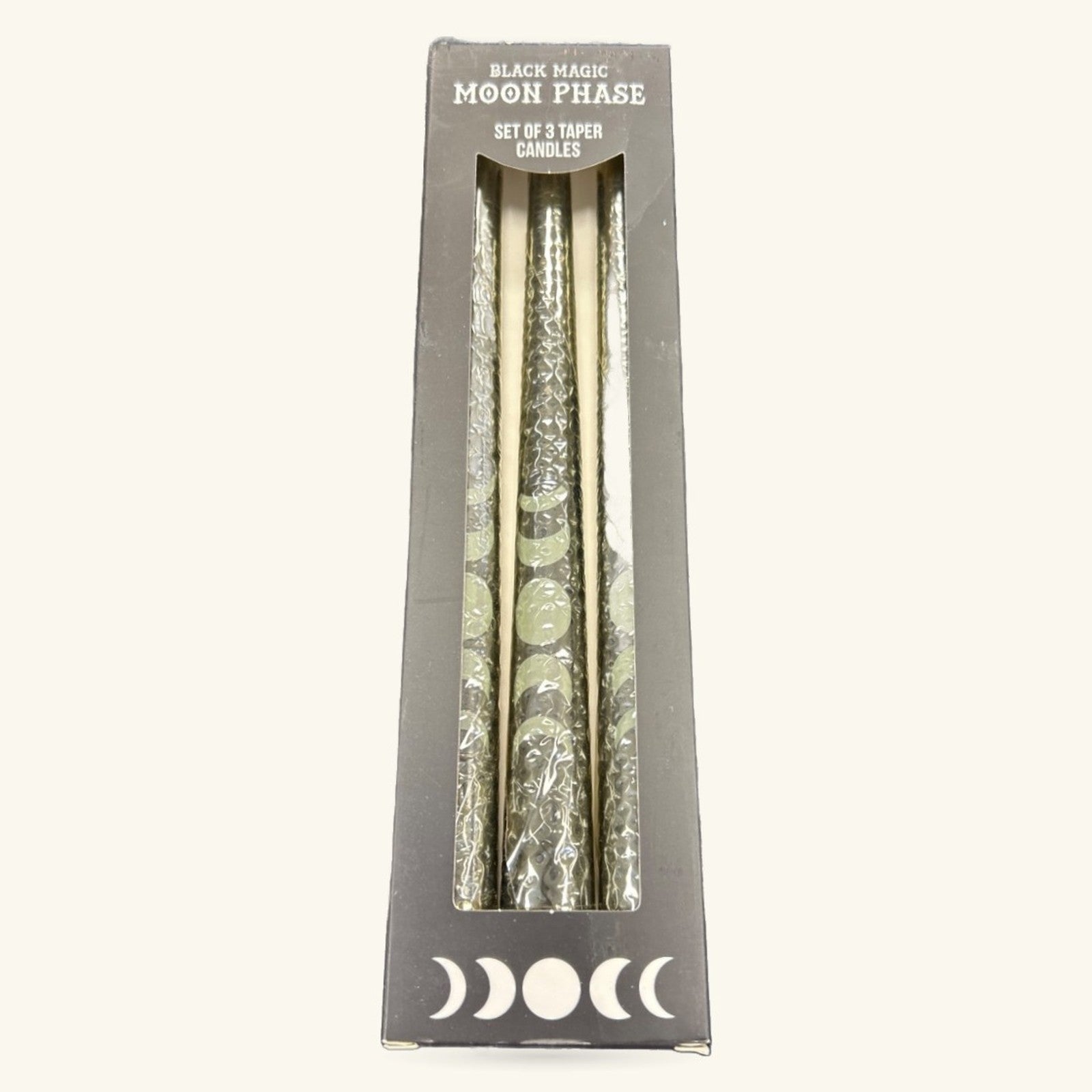Set of three cream taper candles with silver moon phase designs in dark gray packaging box