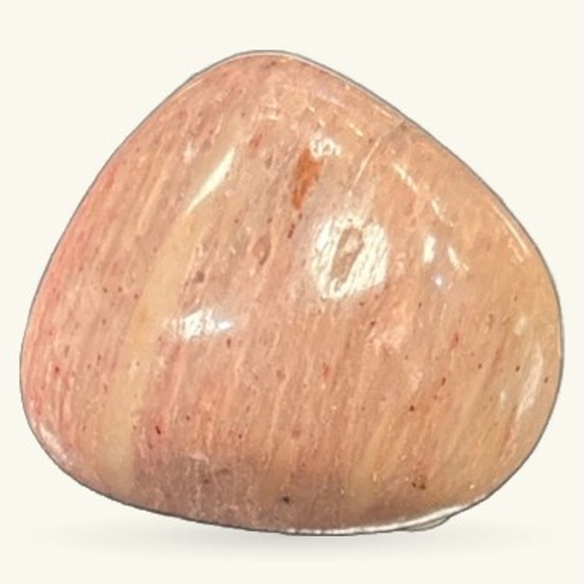 Polished rhodonite tumble stone in warm peachy-pink tones with white striations and natural surface texture