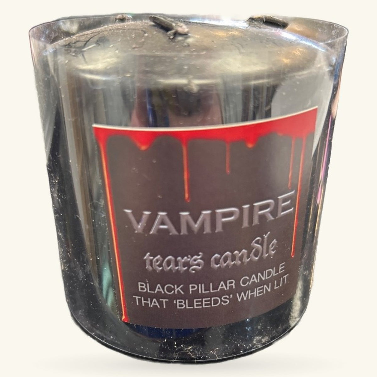 Black pillar candle in clear glass container with red dripping wax design and Vampire Tears label