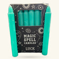 Set of six turquoise spell candles in a black box with mystical silver icons and 'Luck' labeling
