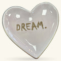 Heart-shaped ceramic trinket tray in pale pink with gold 'DREAM.' text and glossy finish