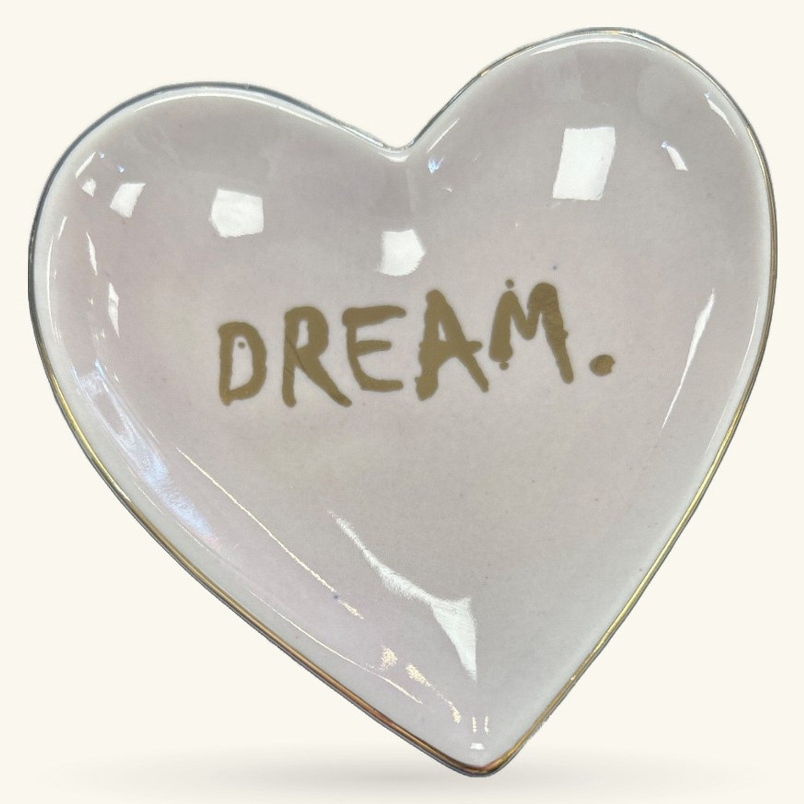 Heart-shaped ceramic trinket tray in pale pink with gold 'DREAM.' text and glossy finish