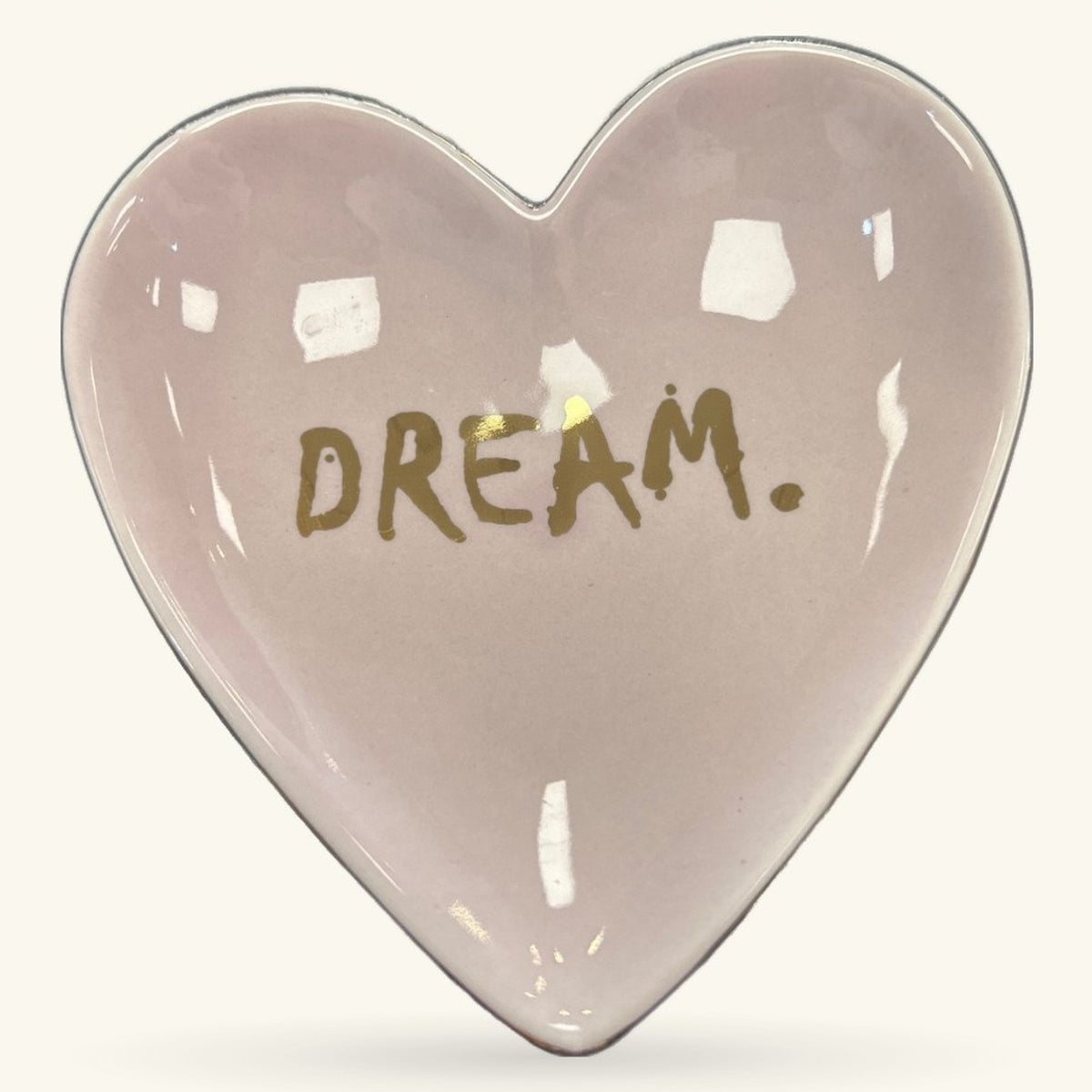 Heart-shaped pink ceramic trinket tray with gold 'DREAM.' text and white glazed accents